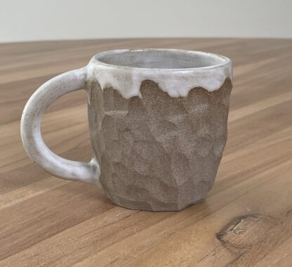 Mug with white glaze and carved into hewn-like pattern