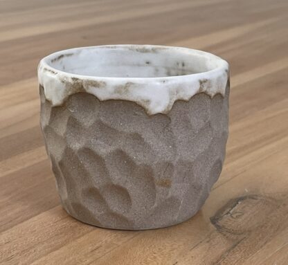 Tumbler with white glaze and carved into hewn-like pattern