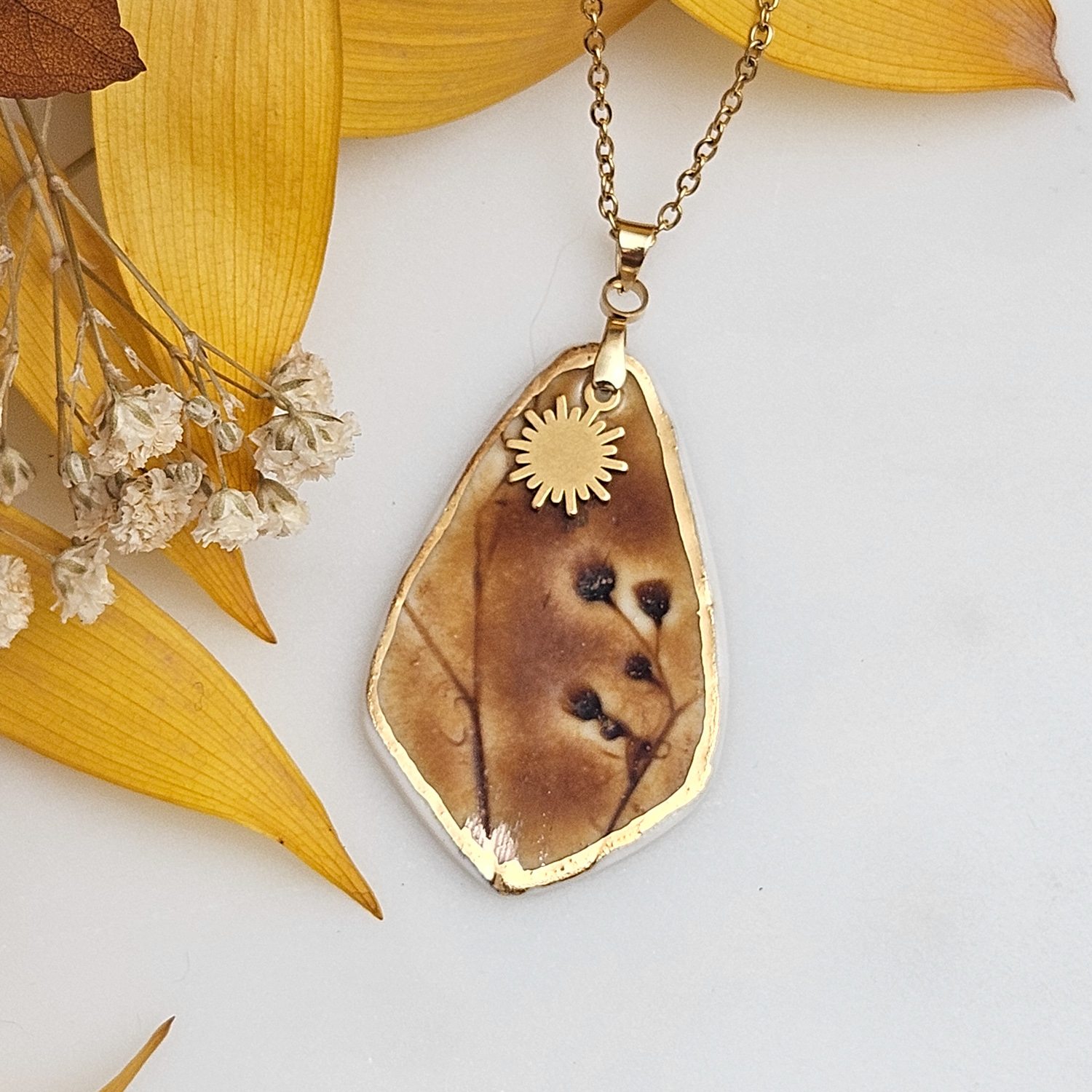 Amber fine ceramic porcelain designer necklace - embossed plant with 22k gold plating and sun pendant