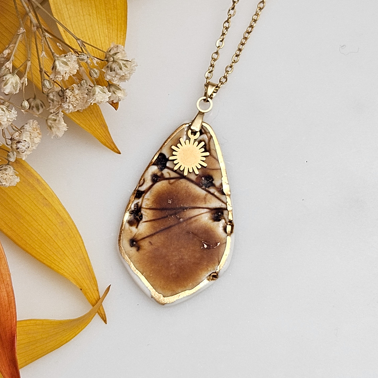 Amber fine ceramic porcelain designer necklace - embossed plant with 22k gold plating and sun pendant